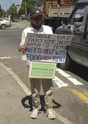 Man stood in carpark holding sign about being single dad