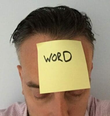 Post-it note with word written stuck to a man's head