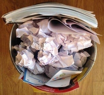 Waste paper bin full of paper and presentation slides