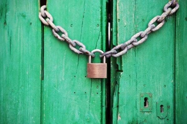 Green door locked by chain and padlock
