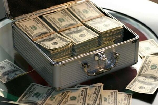 Silver case filled with US bank notes money on a table