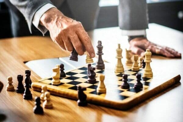 Businessman playing chess using a strategy