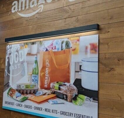 Amazon Go logo above a poster on wooden wall