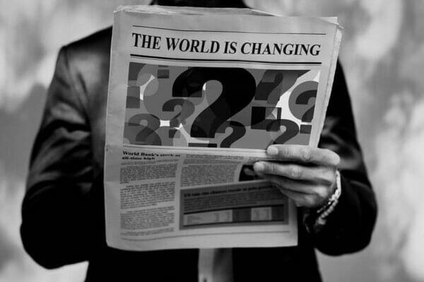 Greyscale Businessman holding a newspaper with the headline The World is Changing
