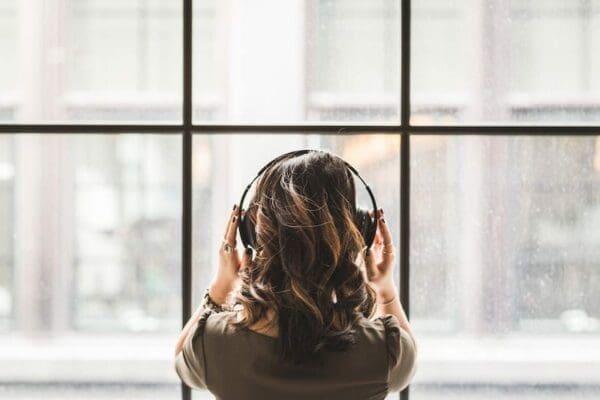 Woman with headphones on looking out of window