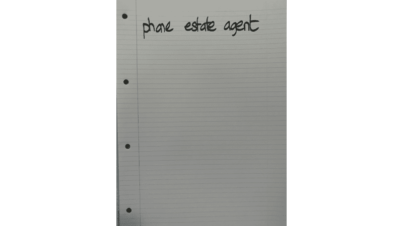 Notebook page with phone estate agent handwritten at the top