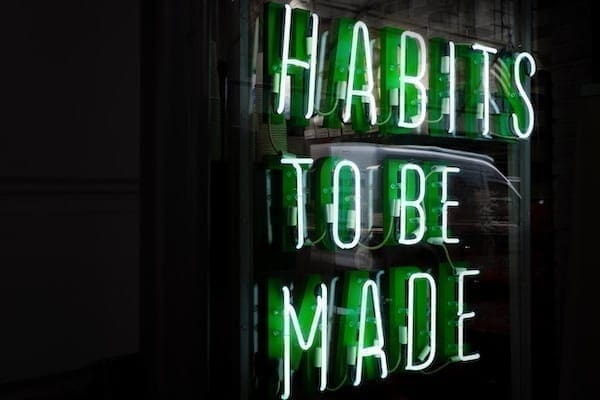 Neon green sign that says Habits to be made