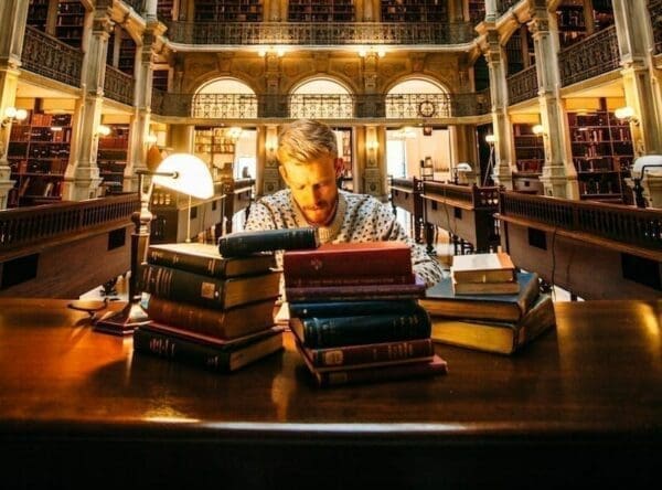 Man working in a library with books in front of him