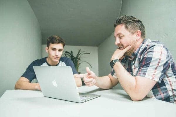 Mentor teaches student from a laptop