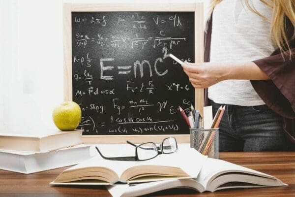 Woman in front of chalk board with E=mc2 albert Einstein formula on it