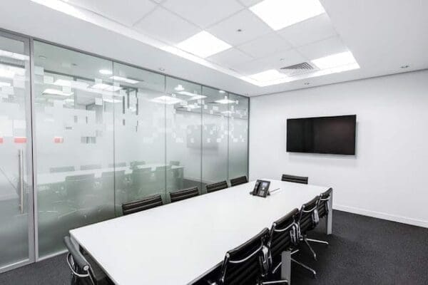 A black and white empty boardroom with chair and a screen.