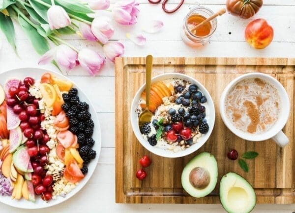 Plates of fruits and berries alongside coffee represent healthy living