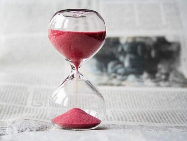 Clear hourglass with red sand for time management tips