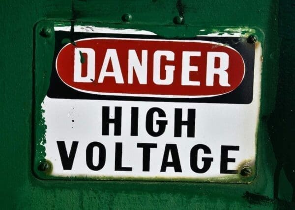A sign saying Danger High Voltage with green background