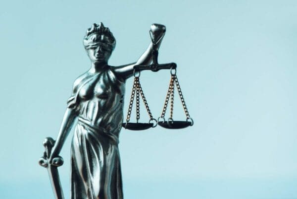 Lady Justice statue holding balanced scales represents trust