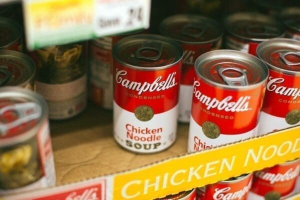 Cans of Campbell's chicken noodle soup on a supermarket shelf