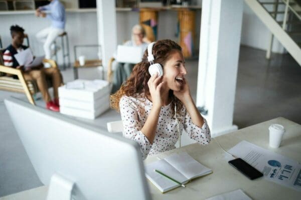 Happy woman with headphones at her desk