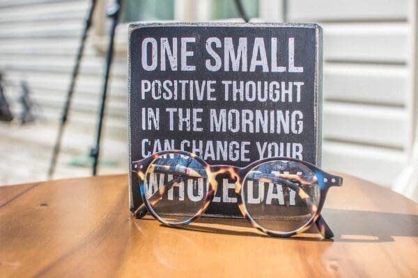 Plaque with positive quote on with glasses in front 