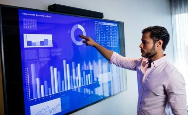 Businessman analysing shopper insight data on an electronic touchscreen 