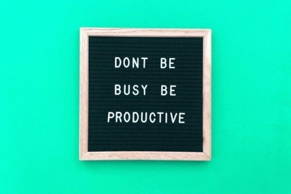 Don’t be busy Be productive quote on a felt board with blue background