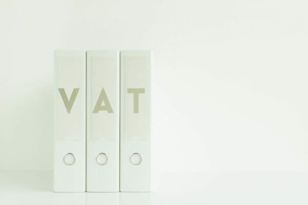 Three white binders with the letters V A T on each one represents Value Added Tax