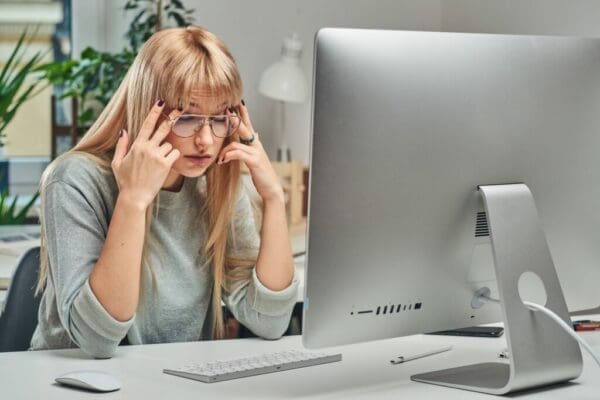 Woman experiencing burnout while working in the office from her computer