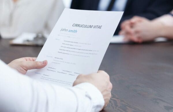 Curriculum Vitae CV held in a woman's hand while at an interview