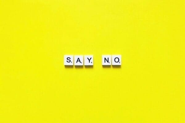 Say No spelled in scrabble tiles on a yellow background