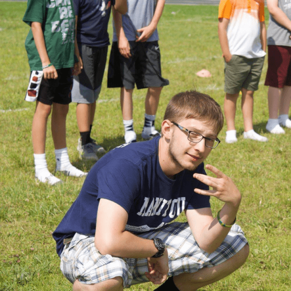 Young Joseph Bunkle graduate student crouching on the floor posing for camera