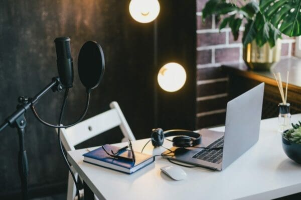 Podcast home station with equipment microphone, earphones and laptop