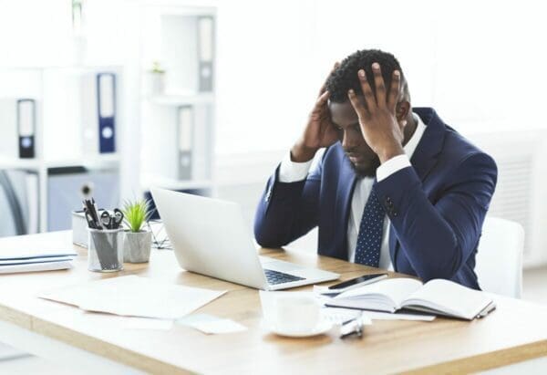 Businessman at a desk is stressed from too many emails