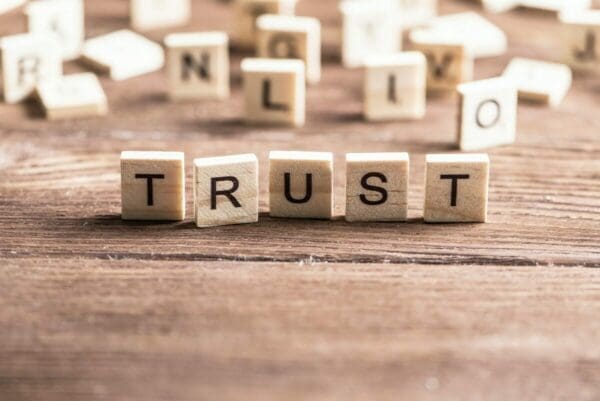 The word Trust is spelt out using small wooden tiles