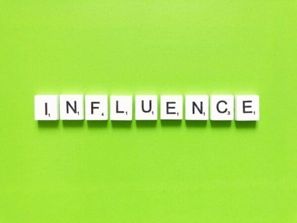 The word influence spelt out in scrabble tiles