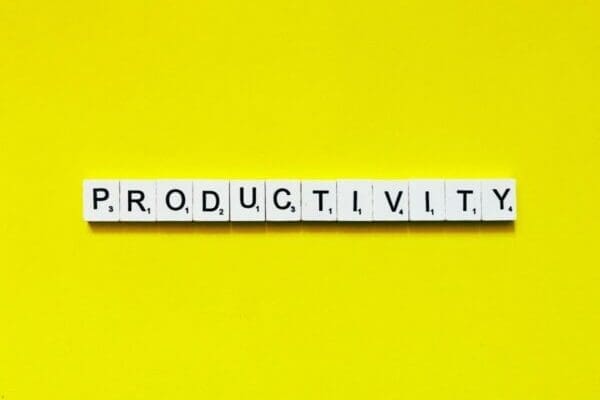 Productivity spelled with scrabble tiles on yellow background