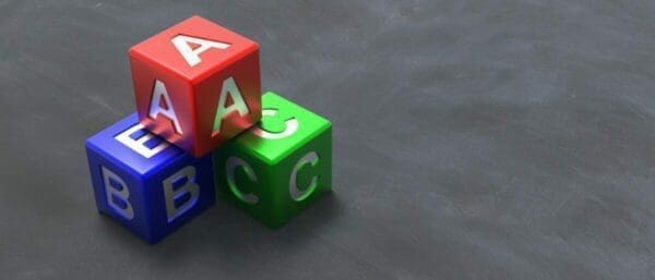 3 coloured blocks with A B and C written on laid on a black surface