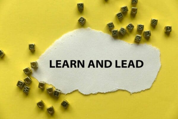 Learn and lead printed on white paper with yellow background