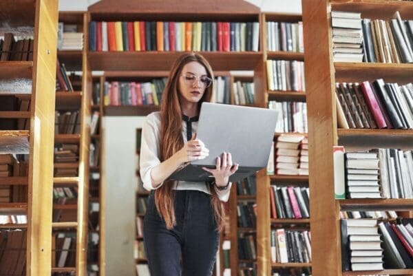 Female leader in a library is learning from her laptop