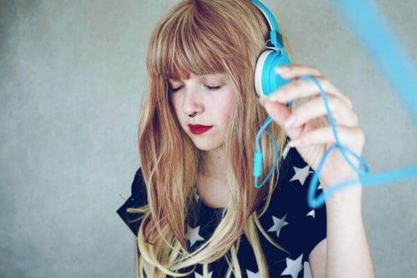 Young woman listening to music with headphones demonstrates active listening