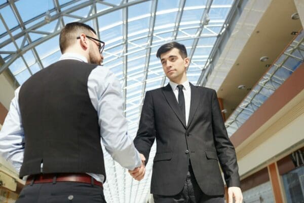 2 businessmen shaking hands outside