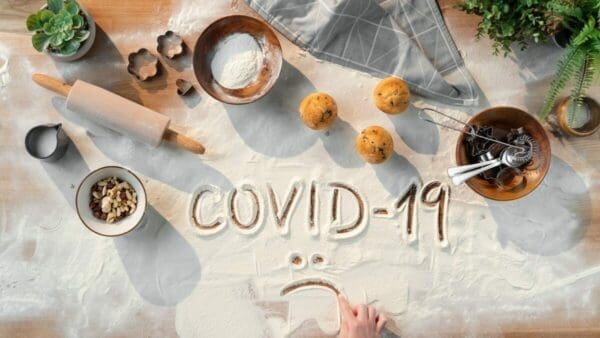 Words Covid-19 written in flour surrounded by ingredients