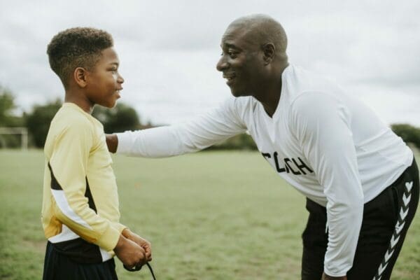 Football coach advising young boy