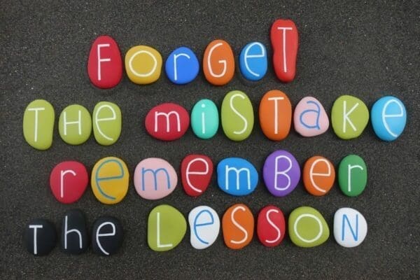 Forget the mistake, remember the lesson, creative and motivational quote on colored stones