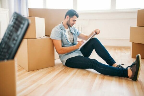 Male employee sitting on ground with boxes from relocation