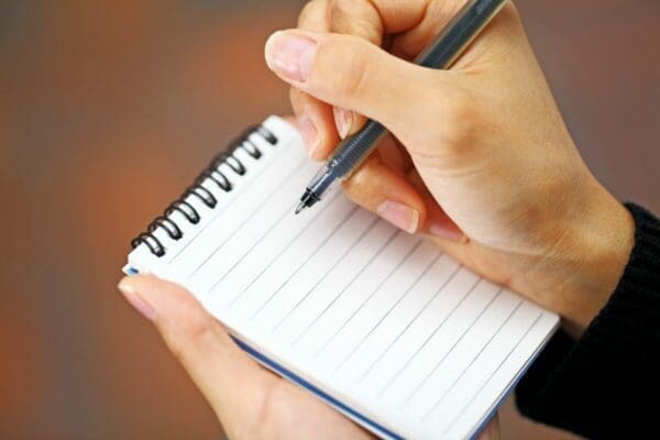 Woman's hand holding a pen on a pad
