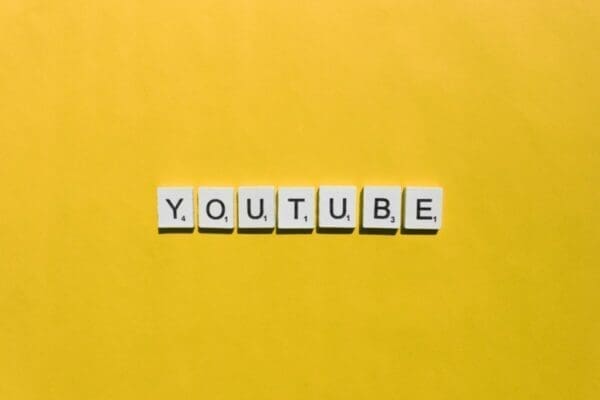 YouTube spelled with word scrabble cubes on yellow background