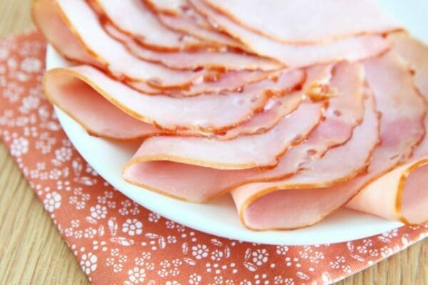 A plate of uncooked folded ham slices