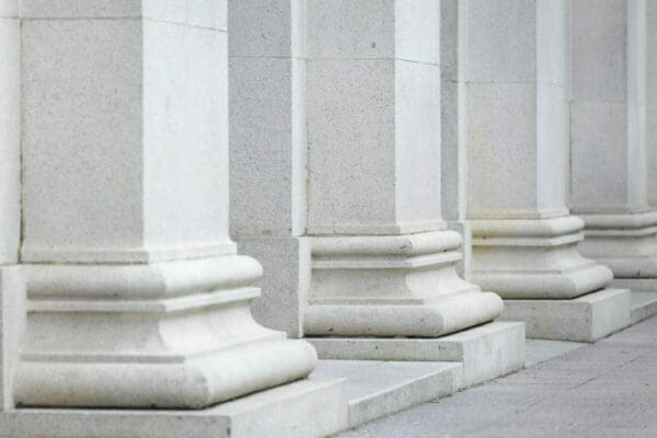 Four white concrete pillars in a row 