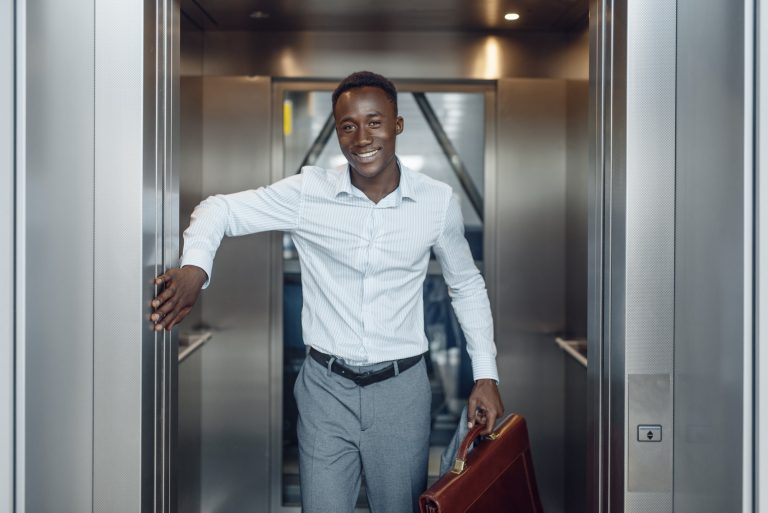 Businessman holding open elevator doors