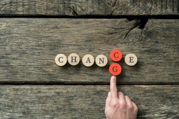 Hand changing the word Chance into Change