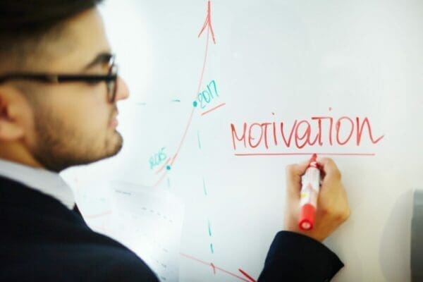 Man writing the word Motivation on a whiteboard